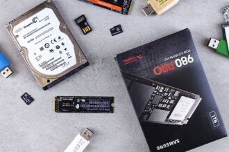 Flat lay of various computer data storage devices on a gray surface.
