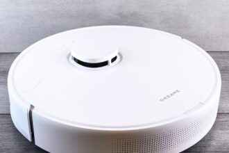 Sleek white robot vacuum cleaner on a wooden floor, perfect for smart home setups.