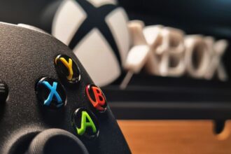 Detailed view of xbox gaming controller with vibrant buttons displayed indoors.