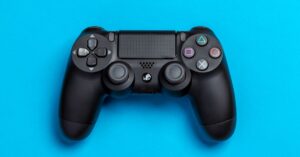 PlayStation game‑sharing meme gets a fresh spin from former Sony execs | Smart Tech, Sharp Takes - CRYOVEX.com Black game controller against a vibrant blue background, perfect for gaming-themed content.