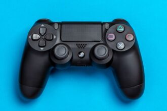 Black game controller against a vibrant blue background, perfect for gaming-themed content.
