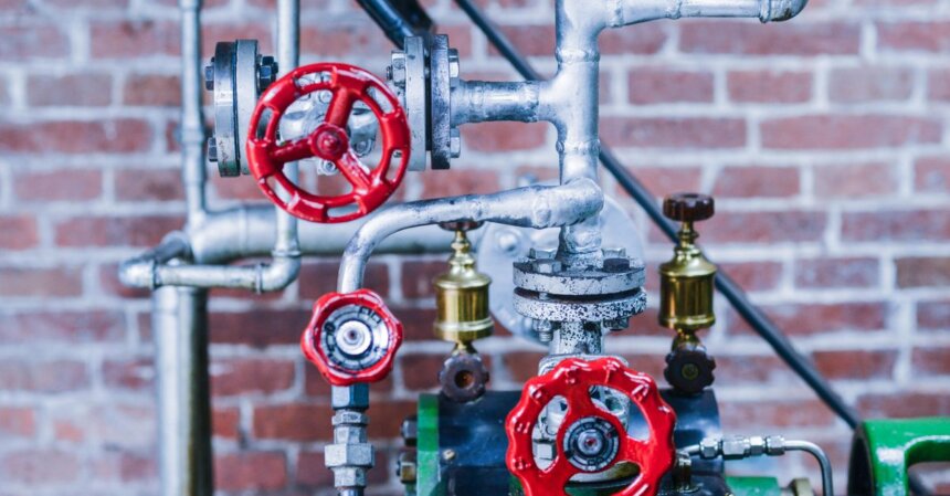 Valve Releases Lepton Android Compatibility Tool as Open-Source | Smart Tech, Sharp Takes - CRYOVEX.com Close-up of industrial machinery with red valve handles and metal pipes against a brick wall.